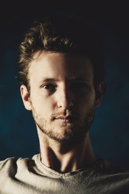 Siyah arka planda genç yakışıklı bir adamın portresi.