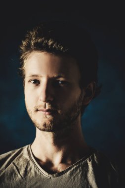 Siyah arka planda genç yakışıklı bir adamın portresi.