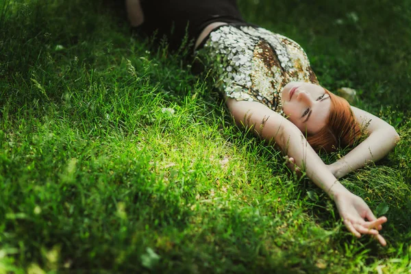 Portrait of young beautiful woman with red hair in golden dress on green grass background — Stock Image Portrait Young Beautiful Woman Red Hair Golden Dress Green Grass Stock Photo