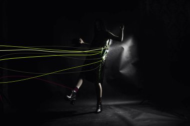 Tam boy siyah stüdyo arka plan, renkli ipler ile içinde siyah genç moda kadın