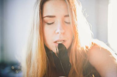 portre genç ifade Kızıl saçlı kadının siyah saten elbise siyah karga tüy holding