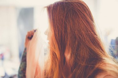 bulanık arka plan üzerinde kırmızı saçlı genç kadın portresi