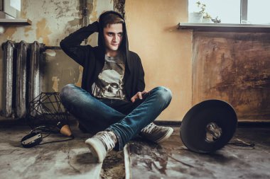 loft tarzı oda katta oturan siyah giysili genç moda adam portresi. 