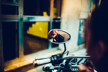 ruj makyaj şehir merkezinde motosiklet aynadaki güzel sevimli kadın fotoğrafı  