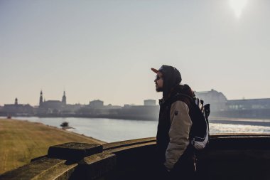 Balkonda güzel tarihi Dresden şehir nehir Elbe ile günbatımı anda Almanya'da arayan genç adam 