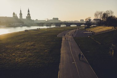 güzel yol ve günbatımı zaman sakin Nehri ile eski şehir silüeti 