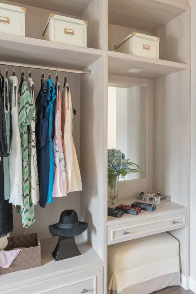 Modern wooden wardrobe with clothes hanging on rail in walk in c — Stock Photo, Image