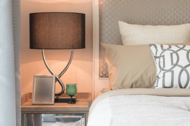 resim çerçevesi ve ahşap masa yan yatak odasında lamba 