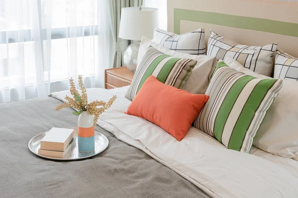 Bunte Kissen auf weißem Bett im modernen Schlafzimmerdesign — Stockfoto