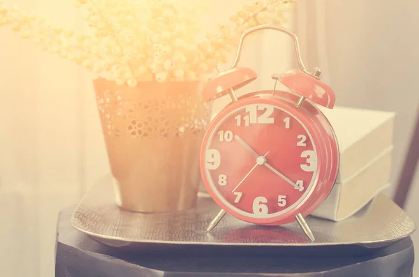 Modern alarm clock on tray with book and plant — Stock Photo, Image