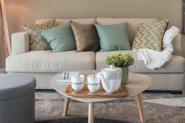 Modern living room with green pillows on cozy sofa and wooden la — Stock Photo, Image