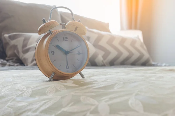 Modern alarm clock on bed in bedroom — Stock Photo, Image