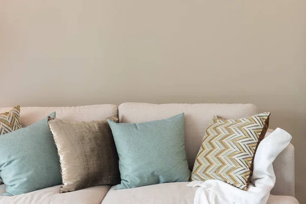 Сучасна вітальня з зеленими подушками на затишному дивані та дерев'яній лазні — стокове фото