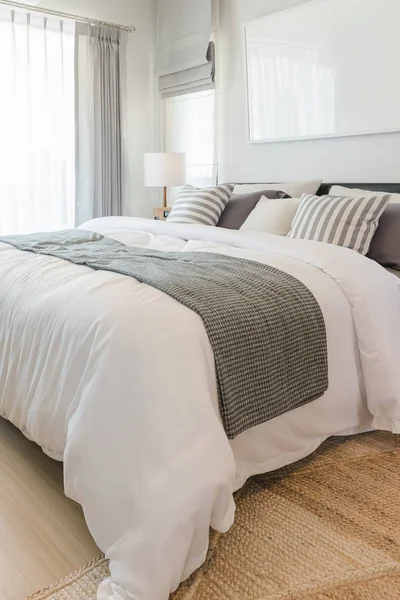 Набор подушек и одеяло на кровати в современной спальне — стоковое фото