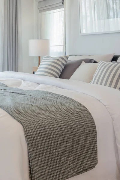 Set of pillows and blanket on bed in modern bedroom — Stock Photo, Image