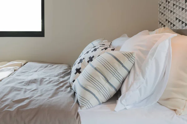 Schwarz-weiße Kissen auf dem Bett im modernen Schlafzimmer — Stockfoto