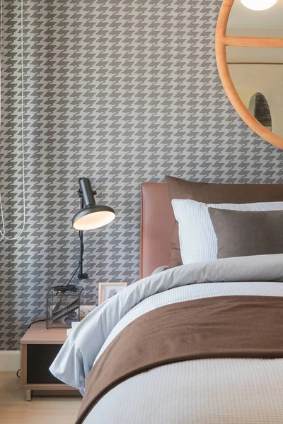 Розкішна спальня з коричневим ліжком і набором подушок, чорна лампа на — стокове фото