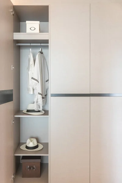 white shirts hanging on rail in wooden wardrobe