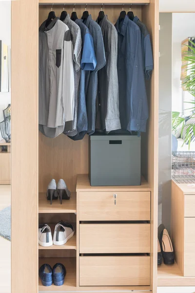 Kleren opknoping op spoor in houten garderobe — Stockfoto