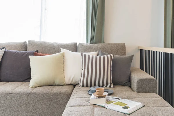 Tazza di tè su libro con divano moderno e set di cuscini in stile moderno — Foto Stock