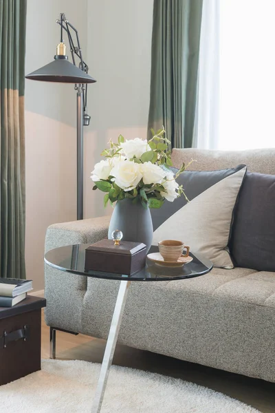 Vas med blomma på runda glasbord med uppsättning soffa i modern l — Stockfoto
