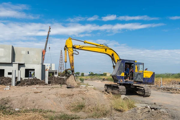 Cantiere con escavatore giallo sporco durante il lavoro — Foto Stock