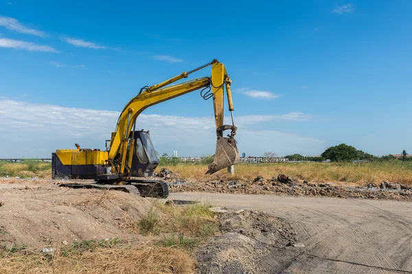 Cantiere con escavatore giallo sporco durante il lavoro — Foto Stock