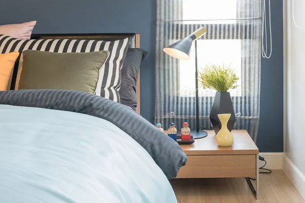 set of pillows on bed with blanket in blue bedroom