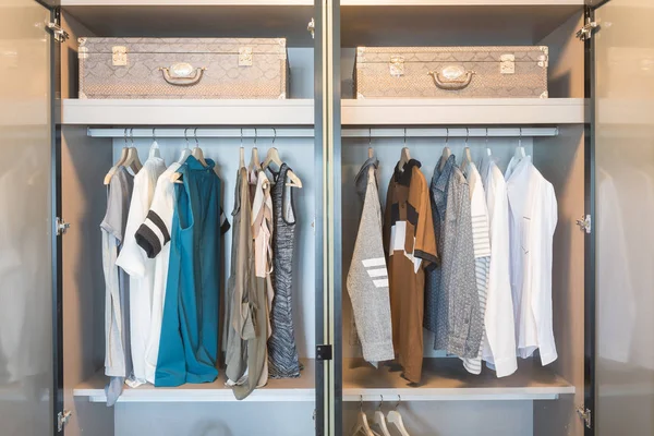 Одежда висит на рельсах в современном гардеробе — стоковое фото