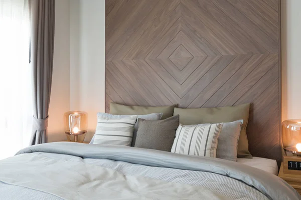 Conjunto de almohadas en la cama con decoración de pared de madera en la tetona clásica — Foto de Stock