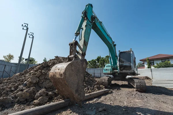 Excavadora en el sitio de construcción, excavadora en un montón de grava con empuje —  Fotos de Stock