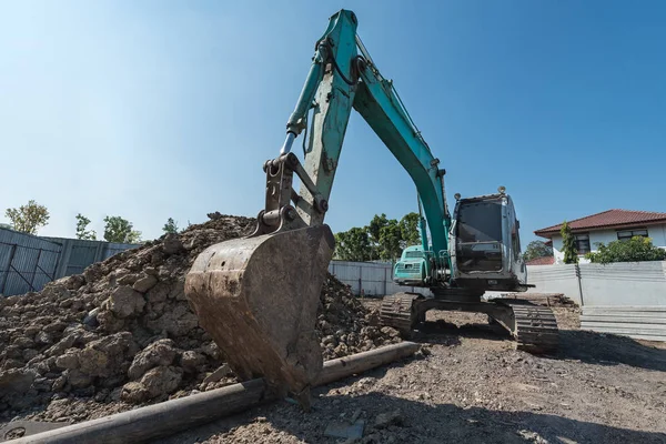 Excavadora en el sitio de construcción, excavadora en un montón de grava con empuje —  Fotos de Stock