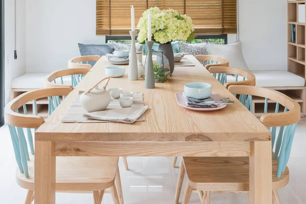 Mesa de comedor de madera en el comedor moderno con juego de mesa y vas —  Fotos de Stock