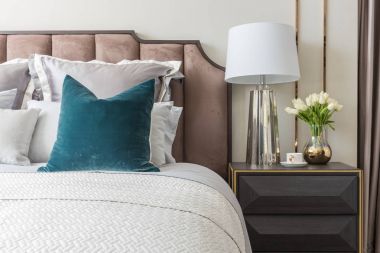 Klasik yatak odası tarzı yastıklar ve lamba masa tarafında dizi