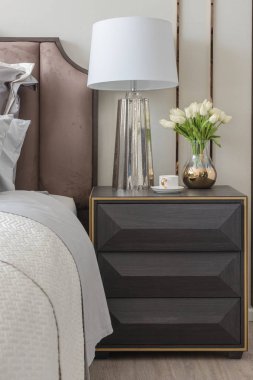 Klasik yatak odası tarzı yastıklar ve lamba masa tarafında dizi