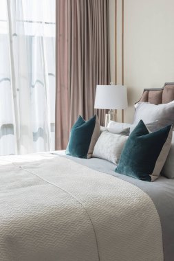 Klasik yatak odası tarzı yastıklar ve lamba masa tarafında dizi