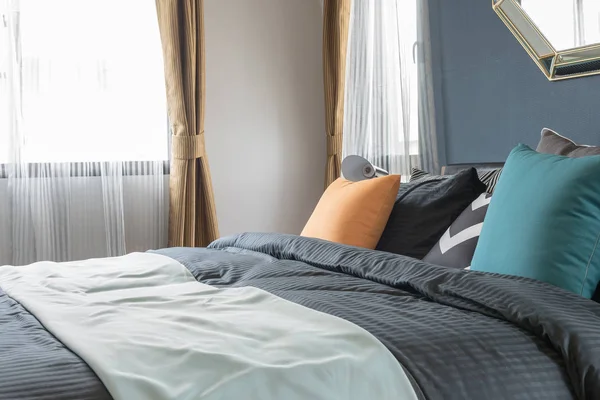 Kleurrijke kussens op donkere kleur bed in moderne slaapkamer — Stockfoto