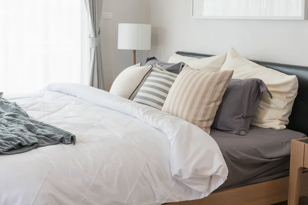 Белое одеяло с набором подушек на кровати — стоковое фото