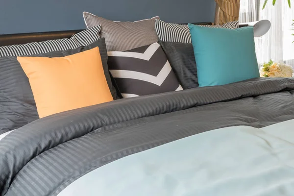 Barevné polštáře na postel tmavou barvu v moderní ložnici — Stock fotografie