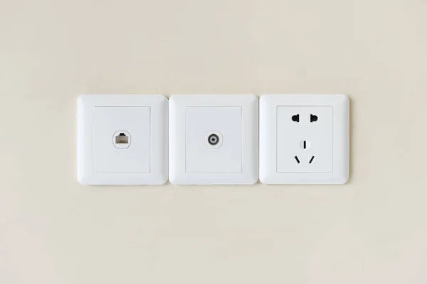 White electric plugs or outlet on wall, with tv and tel — Stock Photo, Image