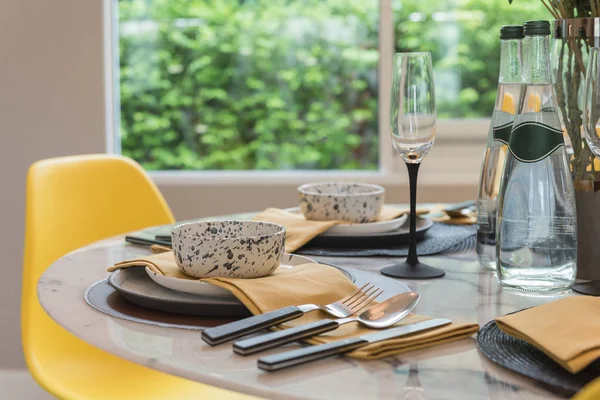 table set on round table with yellow chair