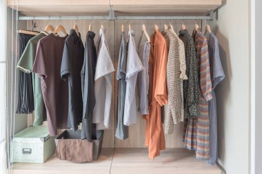 Demiryolu üzerinde asılı giysileri ile ahşap dolap