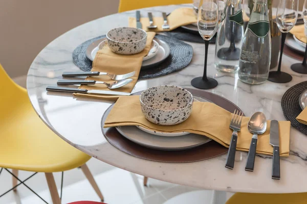 table set on round table with yellow chair