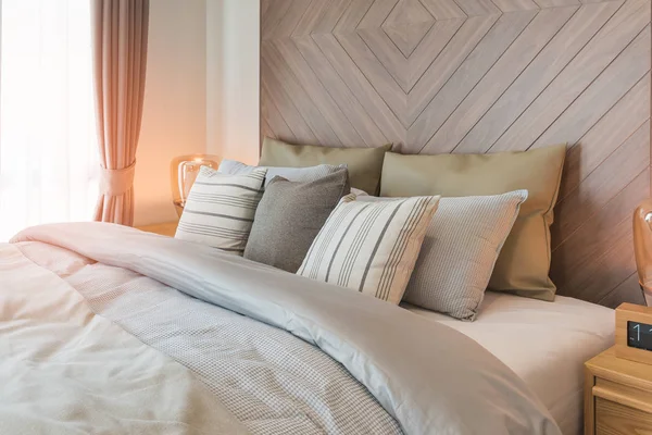 Conjunto de travesseiros na cama com parede de madeira — Fotografia de Stock