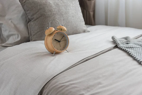 Wooden modern alarm clock on bed — Stock Photo, Image