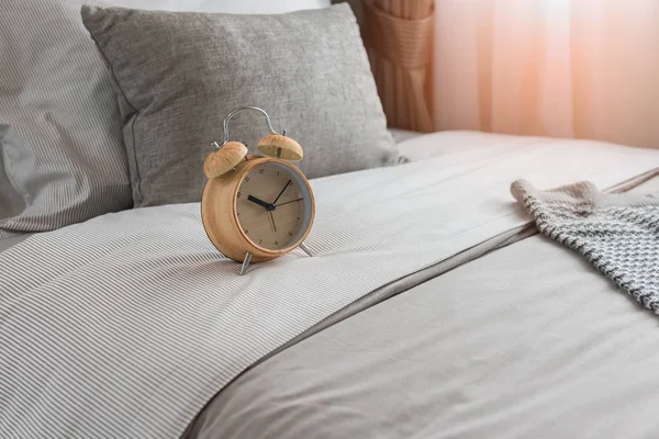 Relógio de alarme moderno de madeira na cama — Fotografia de Stock