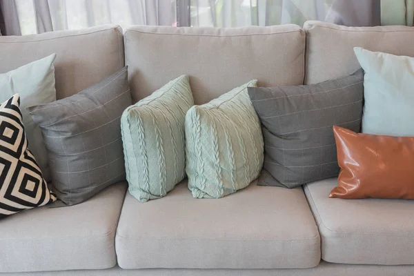 Набор подушек на современном уютном сером диване — стоковое фото
