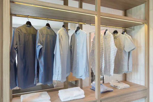 Vêtements suspendus sur rail dans une armoire moderne — Photo