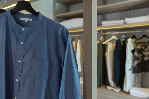 Clothes hanging on rail in modern wardrobe — Stock Photo, Image