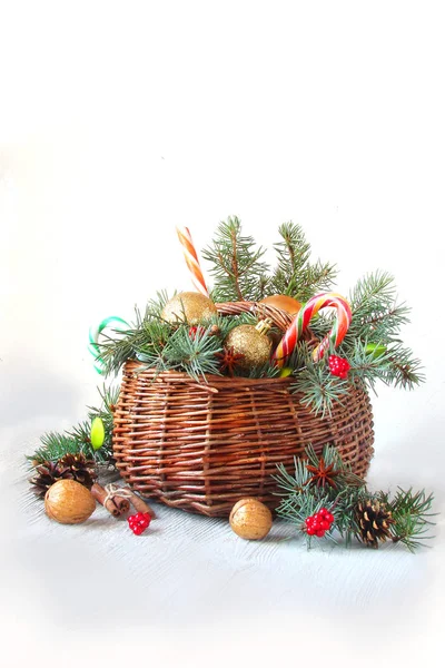 Cesta de Natal com ramos de abeto, brinquedos no fundo branco — Fotografia de Stock